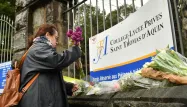 Devant les grilles du collège-lycée, des dizaines d'élèves et de parents déposent des fleurs après l'assassinat d'une professeure d'espagnol.