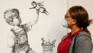 Un tableau du street artist britannique Banksy mettant les soignants à l'honneur s'est arraché aux enchères mardi à Londres à 16,75 millions de livres.