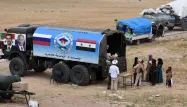 Des membres de la police russe distribue de la nourritures aux populations locales en Syrie.