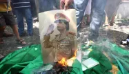 Une photo de Mouammar Kadhafi brûlée lors d'une manifestation d'opposants en 2011.
