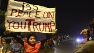 La chanteuse Mai Khoi au moment du passage de la voiture de Donald Trump dans les rues de Hanoï. Sur la pancarte on peut lire "Je te pisse dessus Trump".