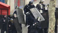 Des policiers se protègent lors de heurts avec les manifestants, à Paris, jeudi