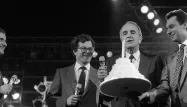 André Rousselet souffle une bougie pour l'anniversaire de la création de Canal+, en 1985, aux côtés de Michel Denisot (à droite).