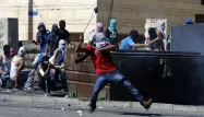 Un jeune Palestinien lance des pierres aux forces de l'ordre dans le camp de Chouafat, à Jérusalem