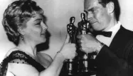 Simone Signoret fêtant, en 1960, son Oscar avec Charlton Heston.