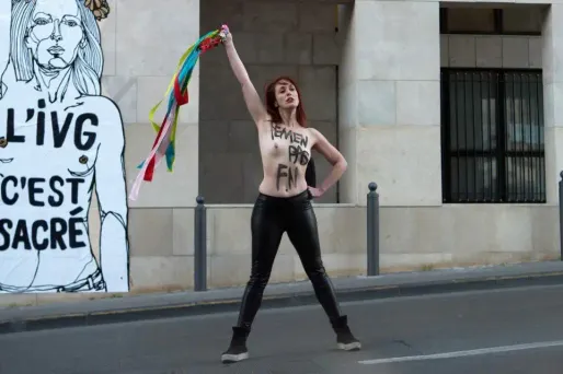 Une militante Femen a posé mercredi devant l'affiche, le slogan "Femen pas FN" peint sur le torse.