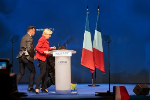 Le service d'ordre de la candidate a rapidement évacué la femme de la scène.