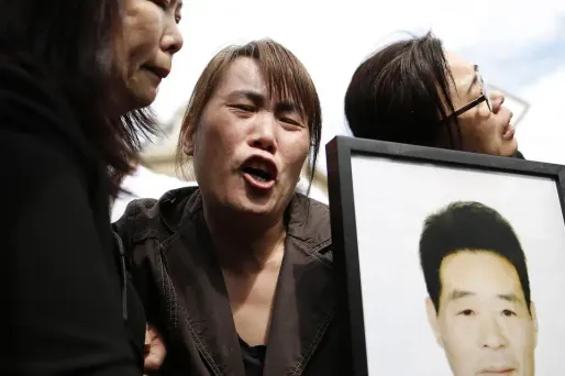 La veuve de Shaoyo Liu (au centre) était présente à la manifestation de dimanche, place de la République à Paris.
