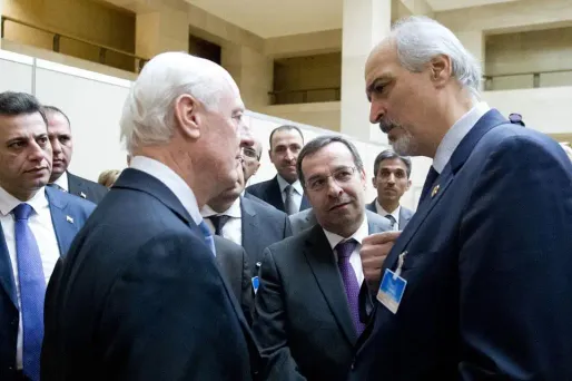 Le chef de la délégation syrienne Bashar al-Jaafari serre la main à l'envoyé de l'ONU pour la Syrie Staffan de Mistura.