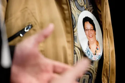 Un membre de la famille d'Anne Barbot porte en souvenir une photo d'elle, à l'ouverture du procès de Didier Barbot et sa maîtresse, jeudi 14 janvier 2016.