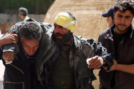 Un homme secouru après les bombardements à Deir al-Assafir jeudi.