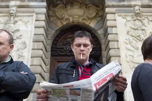 Daniel Legrand fils lit le journal devant le palais de justice de Rennes où il est jugé depuis le 19 mai.