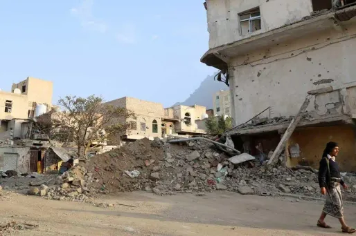 Un habitant de la ville de Taez au Yémen passe devant un bâtiment détruit.