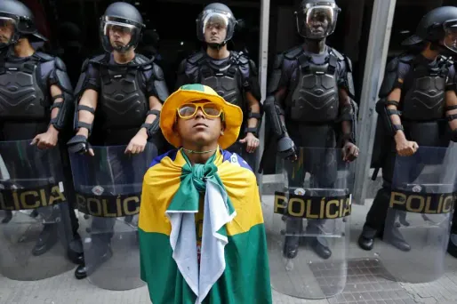 Un manifestant écoute un discours devant une cohorte de policiers brésiliens (illustration)