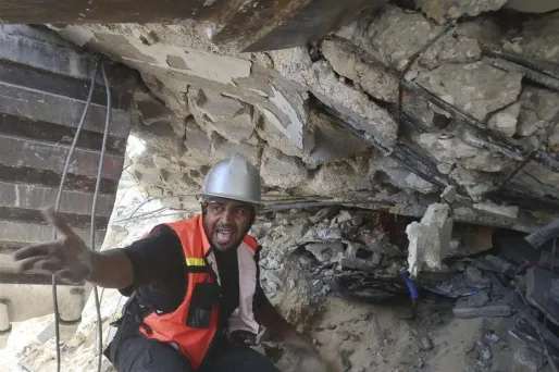 Un homme aperçoit une main dans les décombres à Gaza