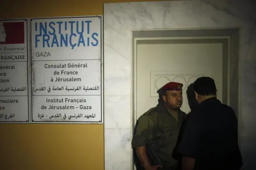 Un membre des forces de l'ordre surveille l'entrée du Centre culturel français de Gaza après l'incendie