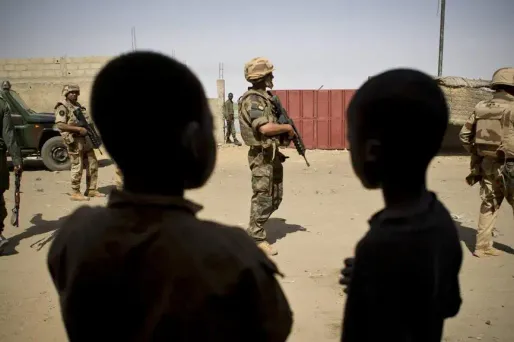 L'armée française sous le regard de deux jeunes garçons maliens à Gao.
