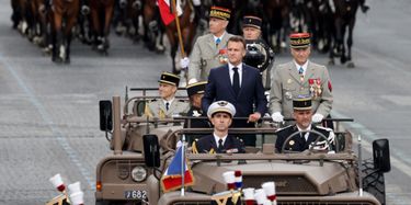 Emmanuel Macron descend les Champs-Élysées à bord d'un véhicule militaire.